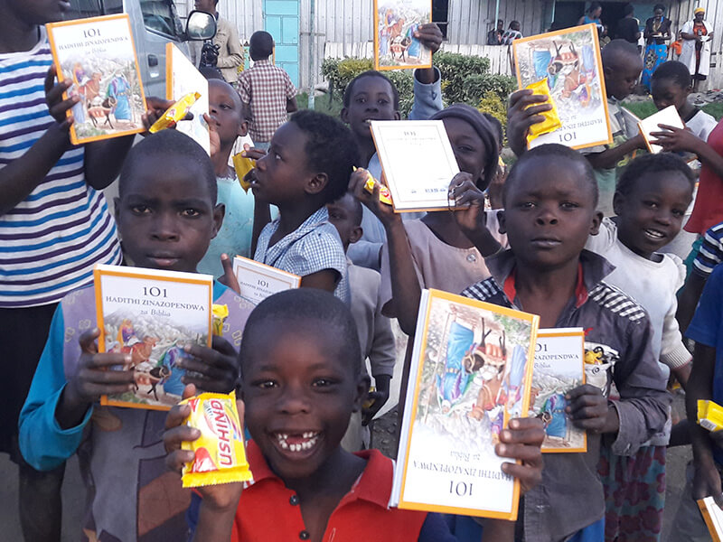 Children holding Bible Story Books