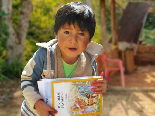 School boy in South America with a copy of CAM’s Bible story book.