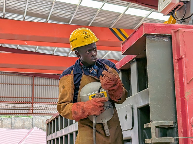 Worker in safety gear operating equipment.