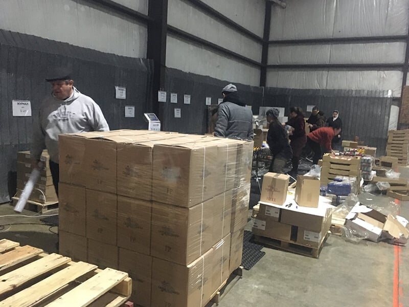 Local volunteers pack food parcels at CAM’s warehouse in Ukraine. 